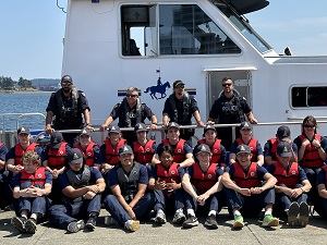 Youths in front of West Coast Marine vessel