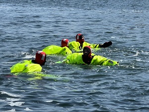 Youths in survival gear floating in ocean